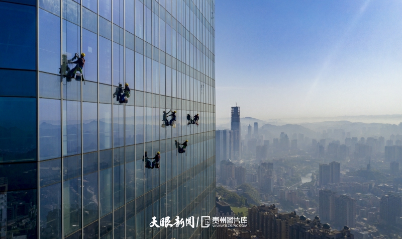 4月8日，在高度335米的贵阳国际贸易中心双子塔，清洗工人从楼顶垂直而下，开展高空作业。.jpg
