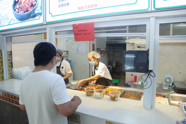 贵州医科大学学生在“贵医爱心餐”供应窗口取餐。